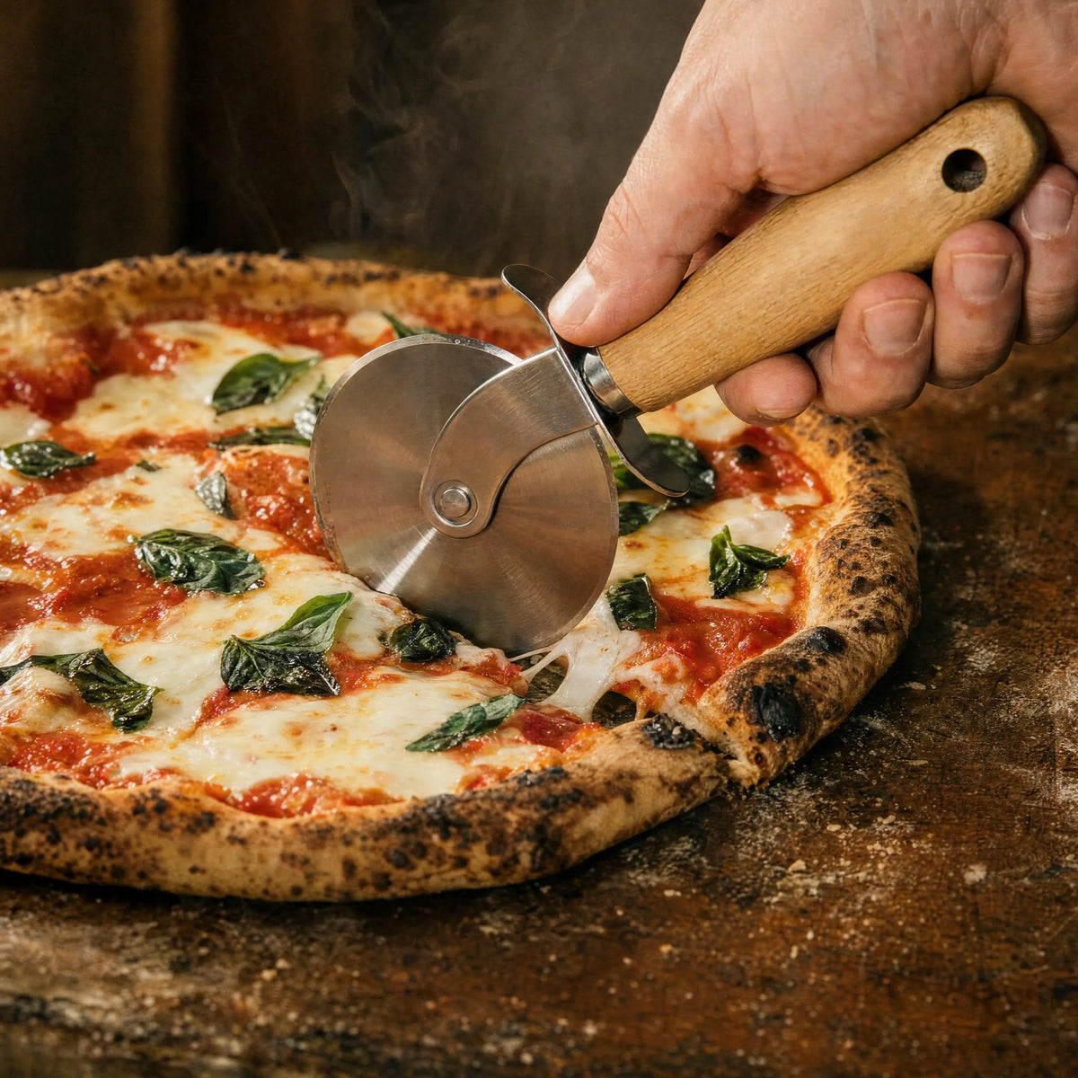 Slicing a homemade margherita pizza with the pizza wheel