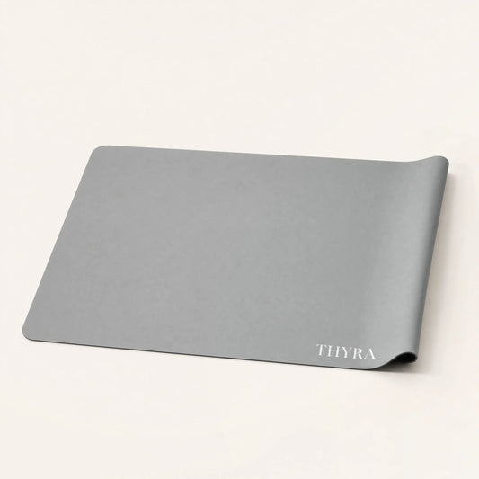 Grey silicone non slip mat for cutting boards on a cream background