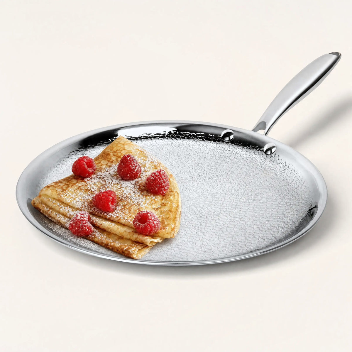 Titanium crepe pan with a folded crepe and raspberries