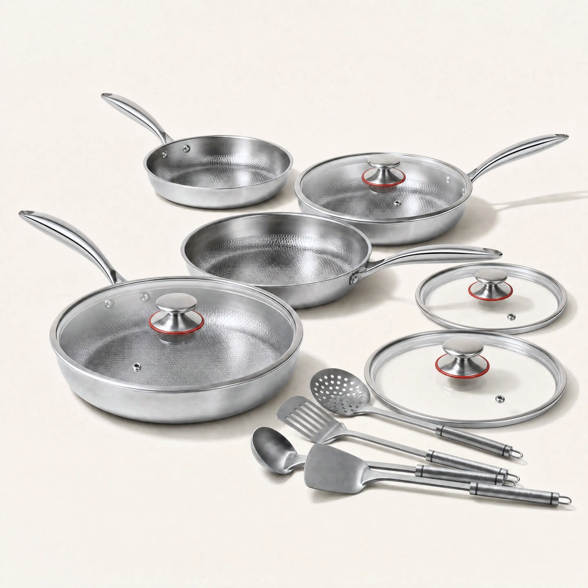 Four pure titanium hammered pans in four sizes with glass lids and titanium utensils