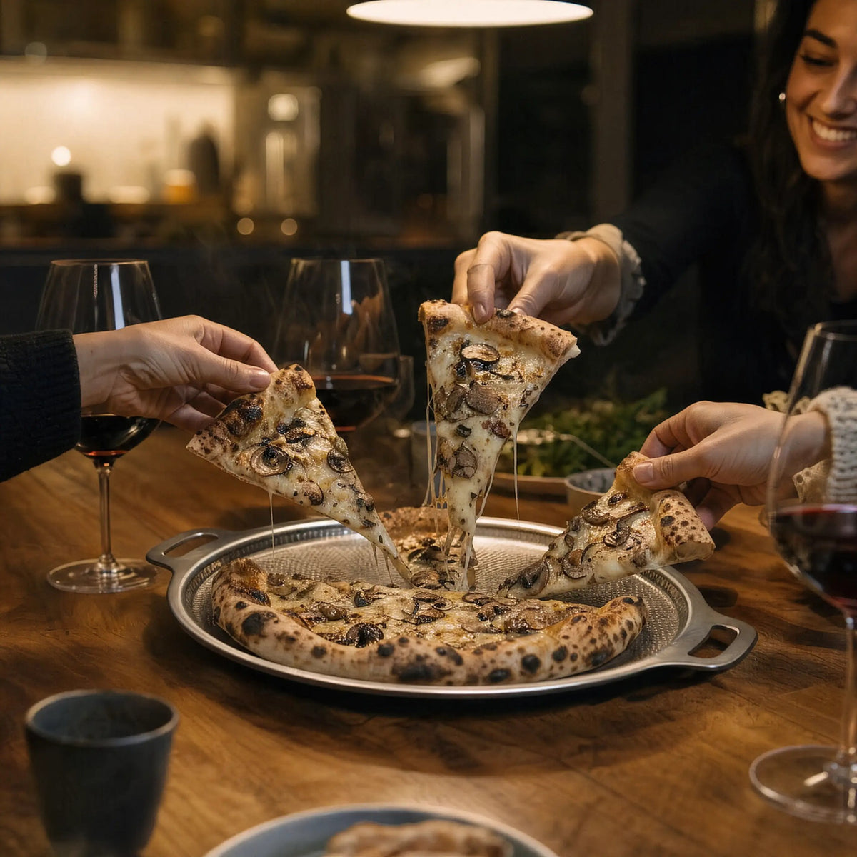 Friends sharing a pizza served on the titanium pizza steel
