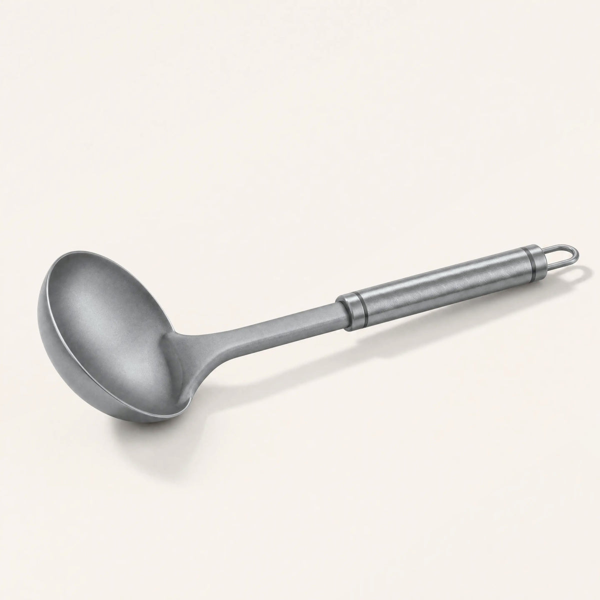 Pure titanium ladle on a cream background