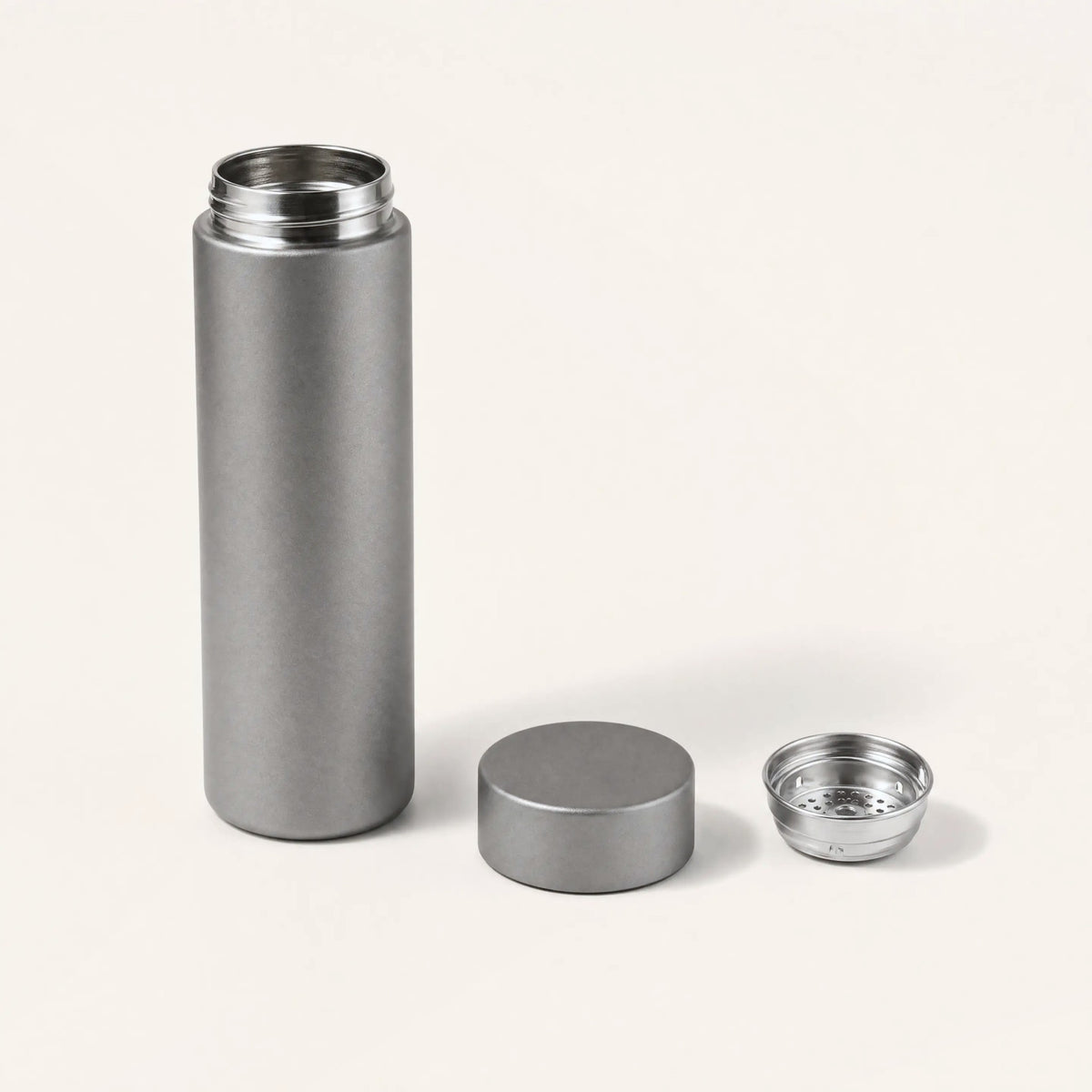 Titanium water bottle with its cap and stainless steel strainer